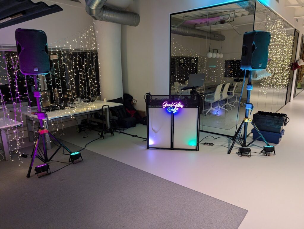 Professionele DJ-booth met geluidsinstallatie en sfeerverlichting op een bedrijfslocatie