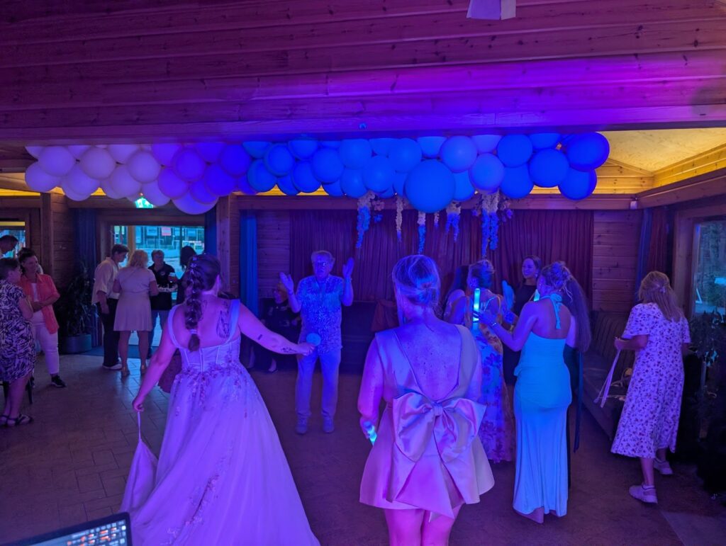 Bruid en gasten dansen tijdens een bruiloftsfeest met sfeerverlichting